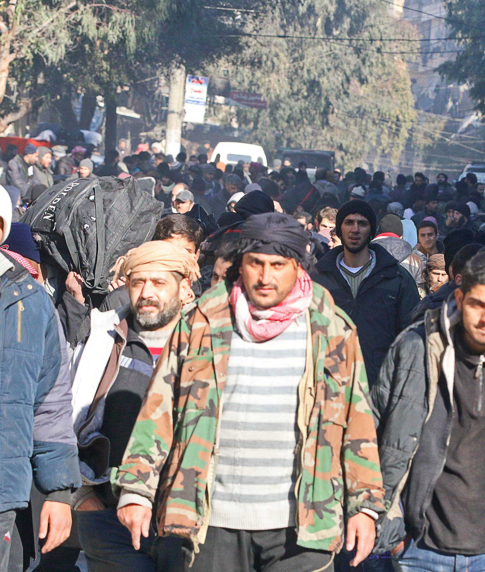 People gather to be evacuated from a rebel-held sector of eastern Aleppo