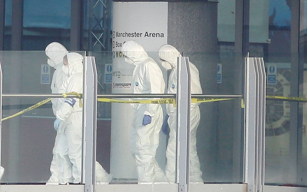 Forensics investigators work at the entrance of the Manchester Arena