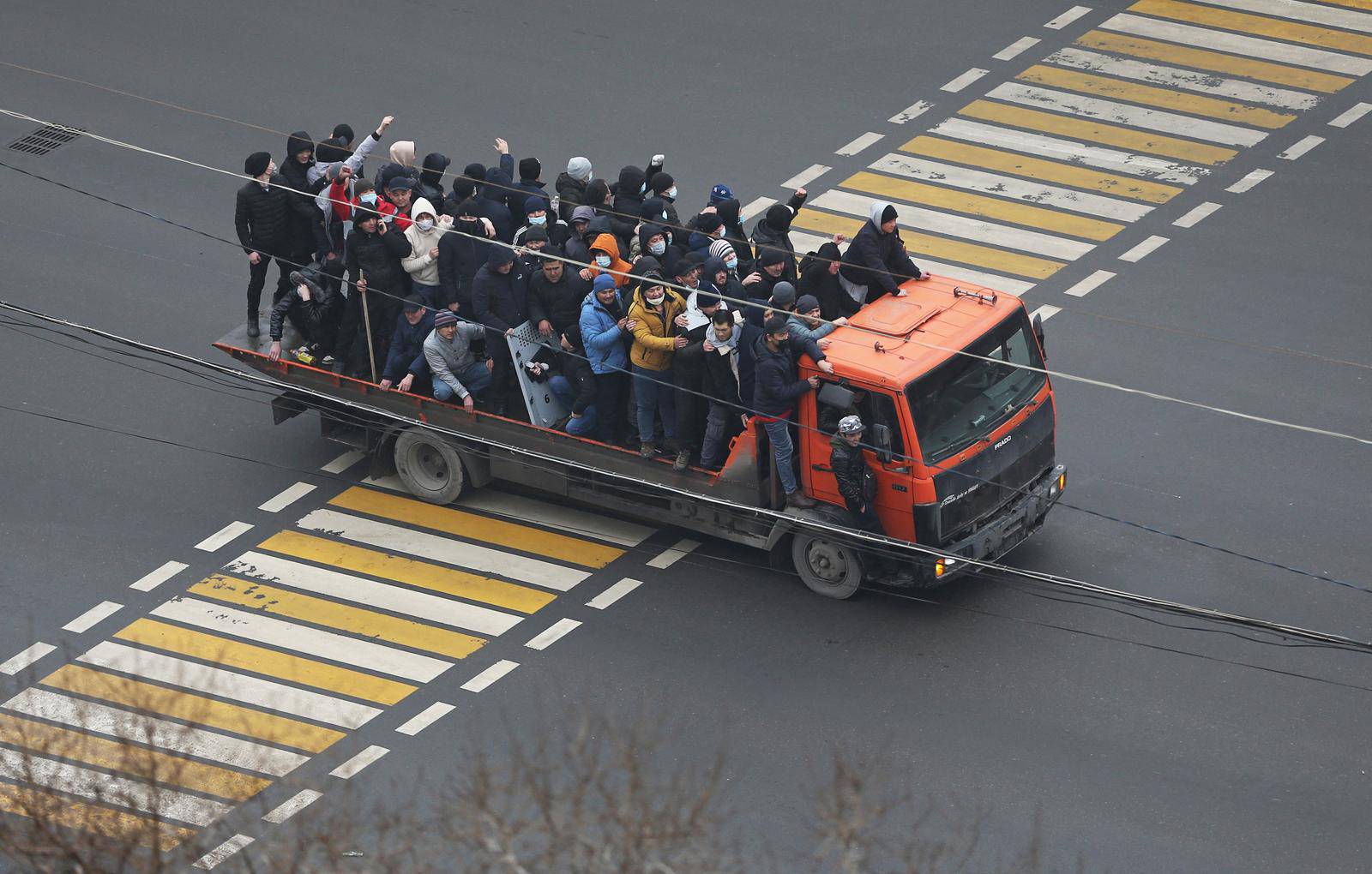 Demonstrators ride a truck during a protest triggered by fuel price increase in Almaty
