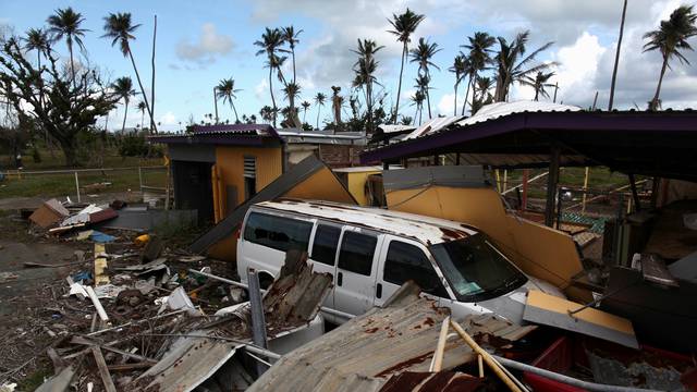 FILE PHOTO:  A car is partially buried under the remains of a building, after Hurricane Maria hit the island in September, in Humacao