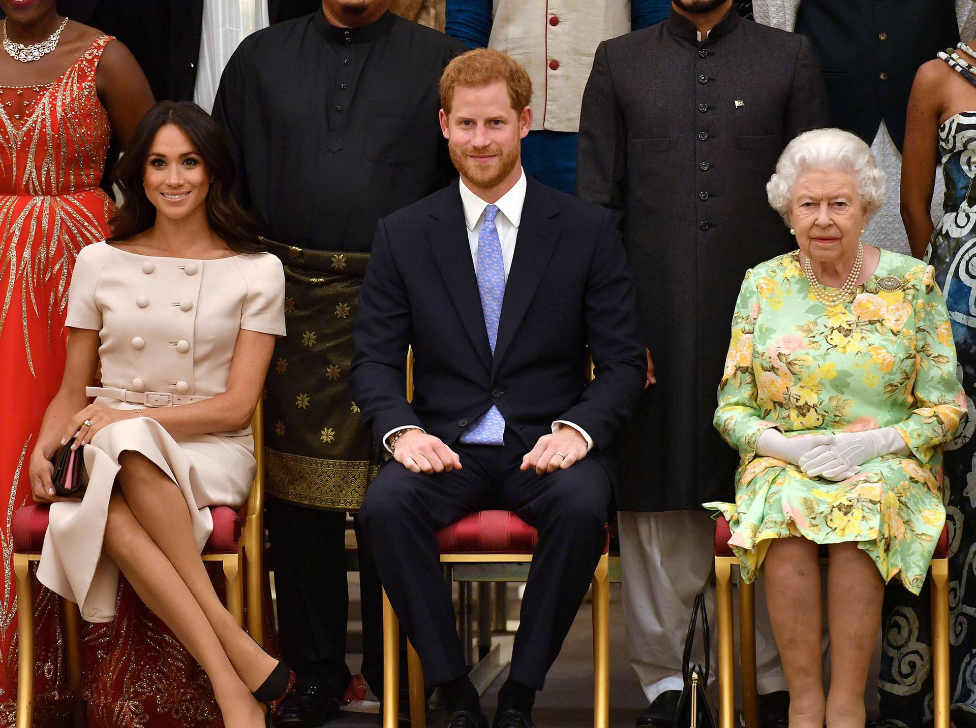 FILE PHOTO: Britain's Queen Elizabeth, Prince Harry and Meghan, the Duchess of Sussex pose for a picture with some of Queen's Young Leaders at a Buckingham Palace reception following the final Queen's Young Leaders Awards Ceremony, in London