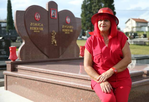 Zorica Rebernik, obsessed with the red color, sits on her grave in the village of Breze near Tuzla