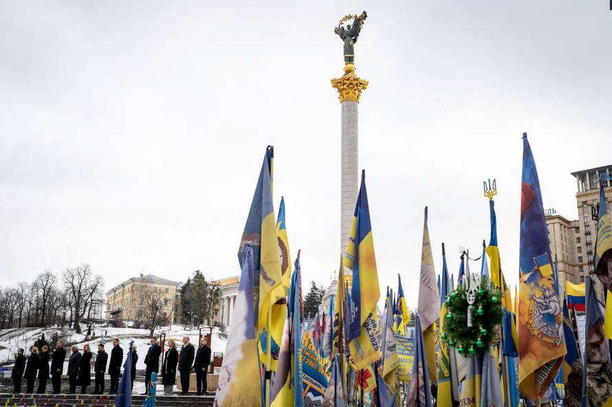 Ukraine's President Zelenskiy his wife Olena and foreign leader visit a makeshift memorial to fallen Ukrainian defenders at the Independent Square on the fourth anniversary of Russia's full-scale invasion, in Kyiv