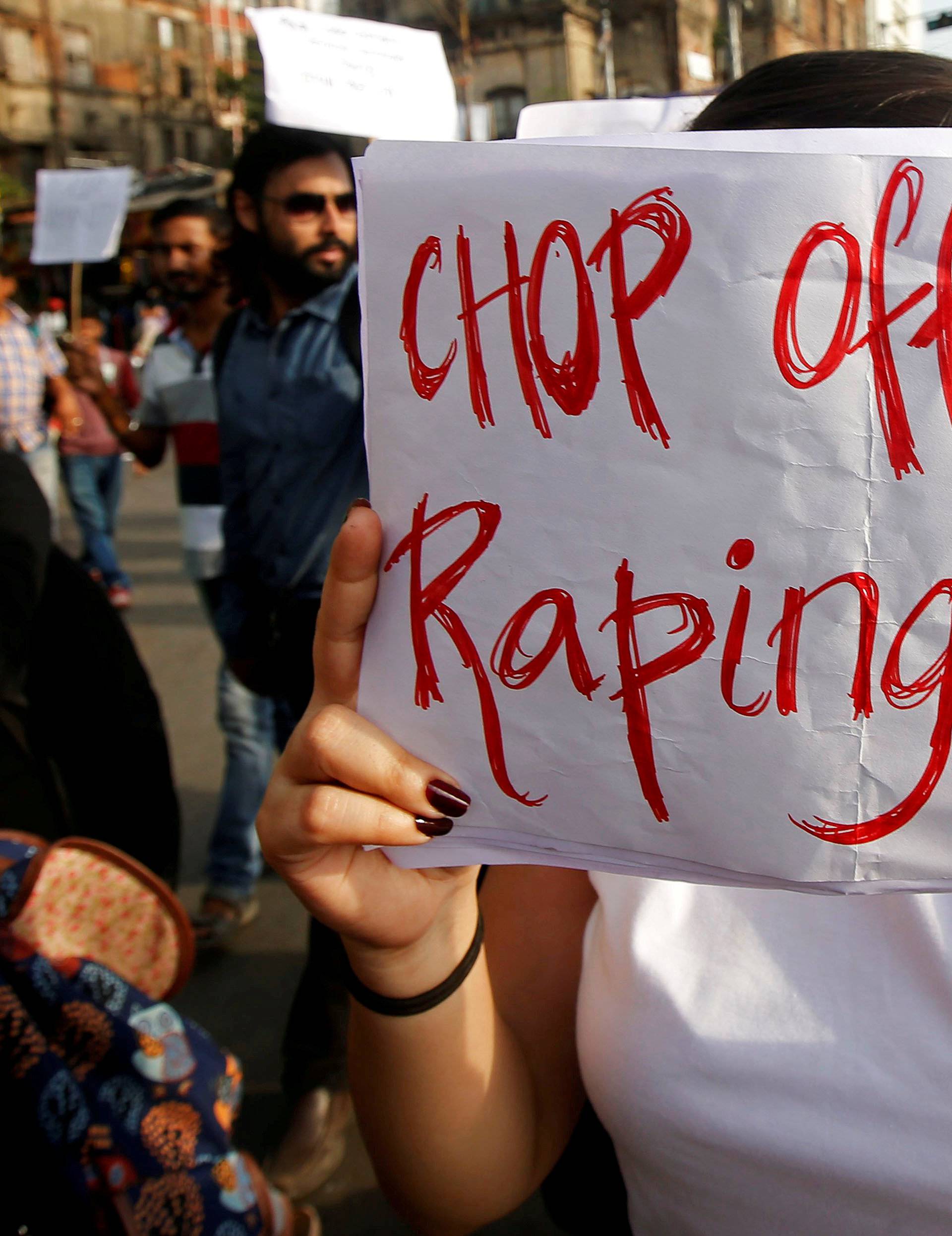 FILE PHOTO: A woman holds a placard during a protest against the rape of an eight-year-old girl in Kathua near Jammu, and a teenager in Unnao, Uttar Pradesh state, in Kolkata