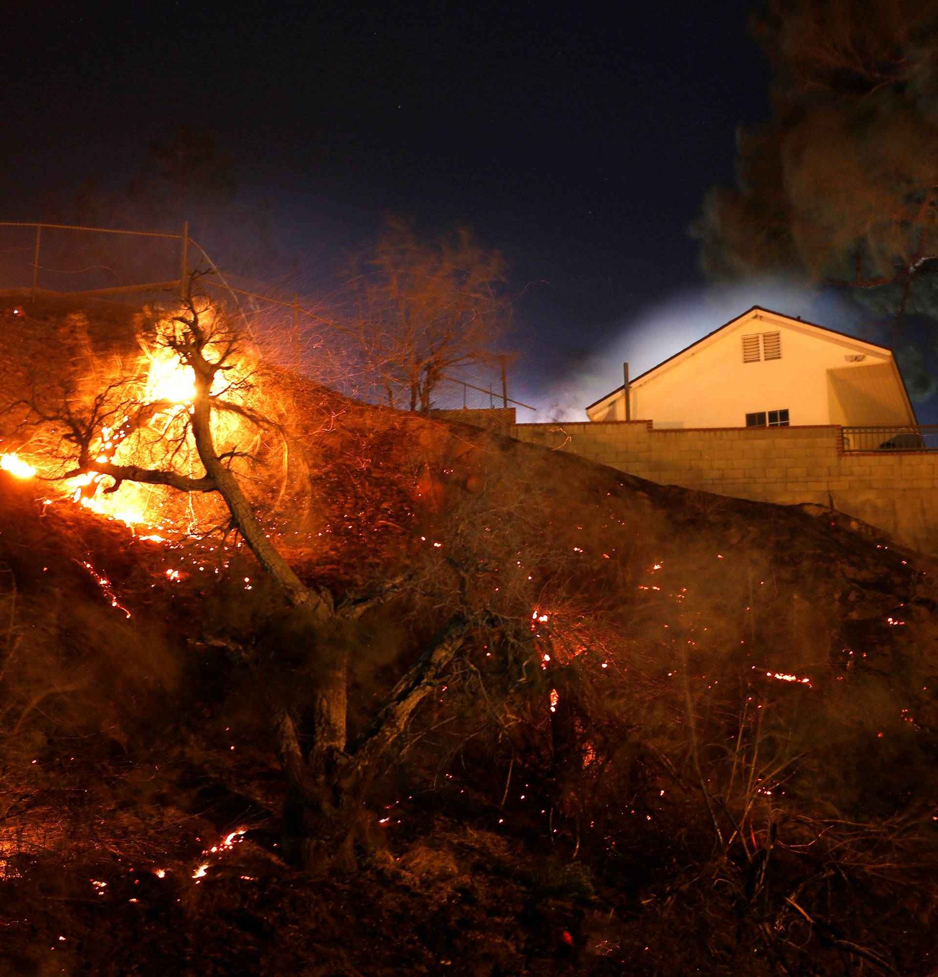 Embers continue burning near a home that was damaged during the Creek Fire in Sylmar, California