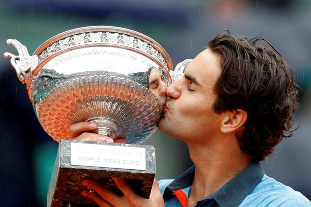 FILE PHOTO: Federer of Switzerland kisses his trophy after winning the men's final against Soderling of Sweden at the French Open tennis tournament at Roland Garros in Paris