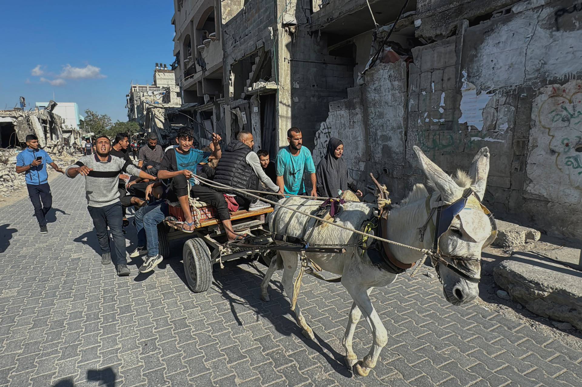 Palestinians assist casualties following an Israeli strike, in Beit Lahiya