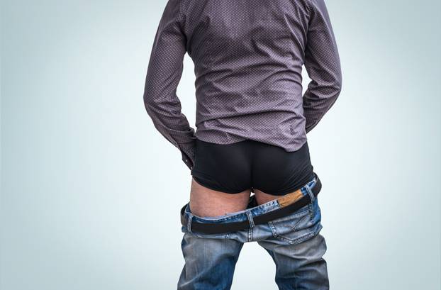 Standing man has undress jeans and peeing