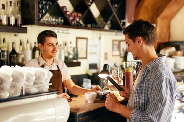 Customer Paying With Mobile Phone In Cafe