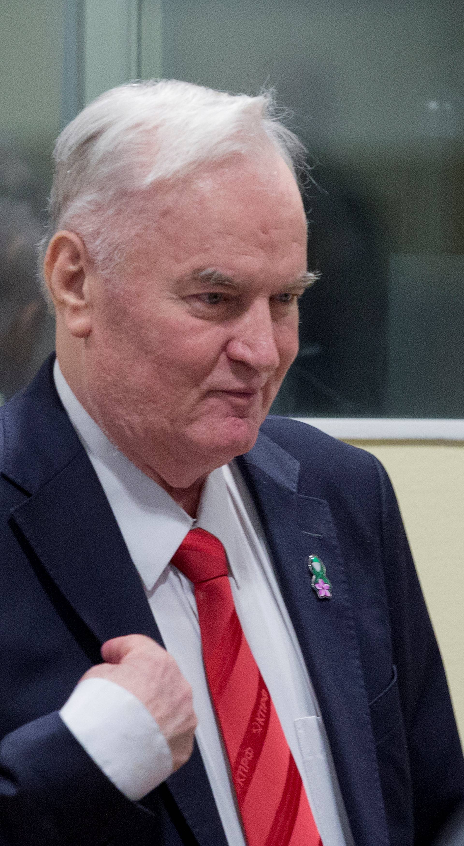 Ex-Bosnian Serb wartime general Ratko Mladic makes the sign of the cross while appearing in court at the International Criminal Tribunal for the former Yugoslavia in the Hague