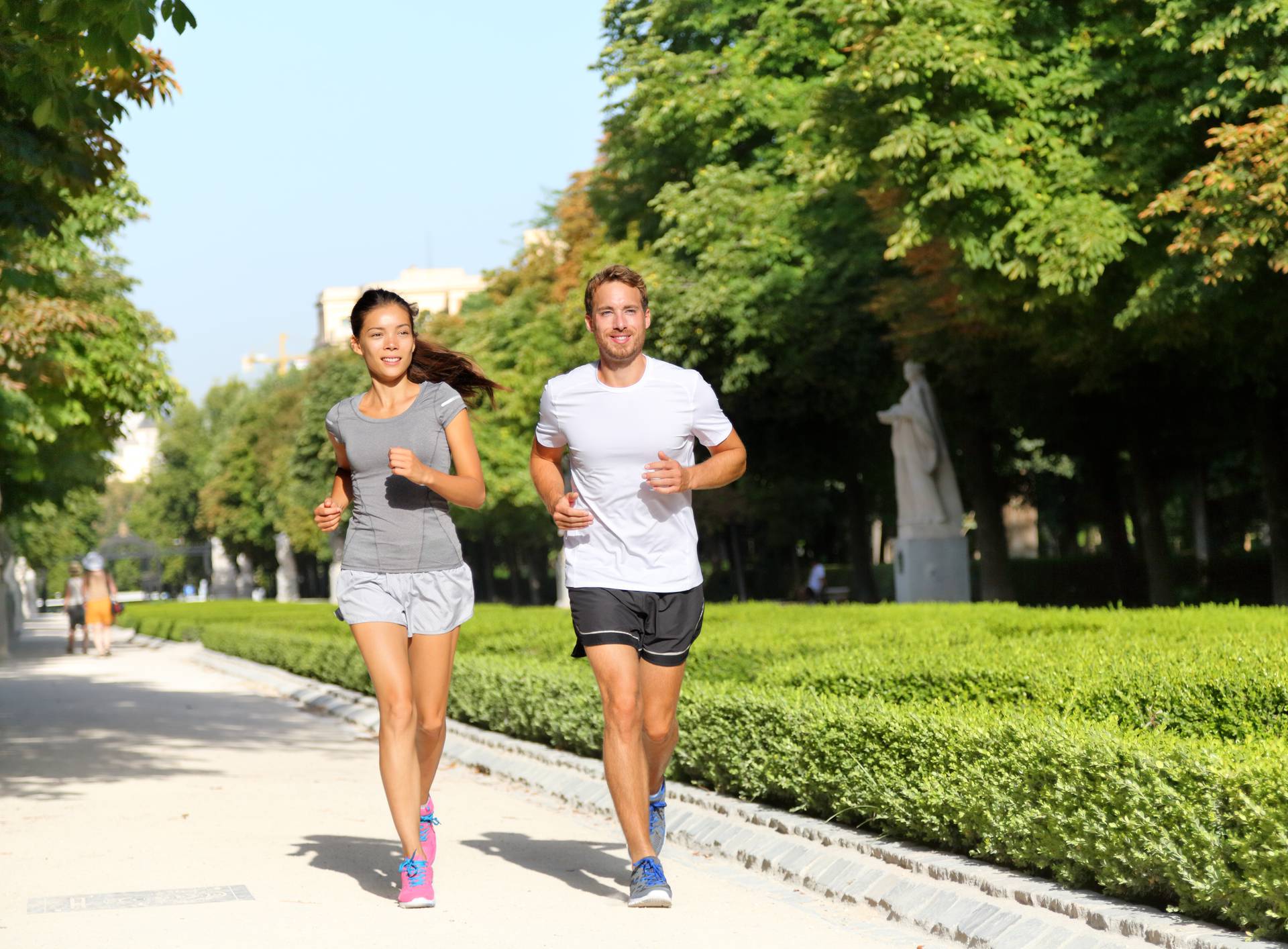 Running couple runners jogging in city park