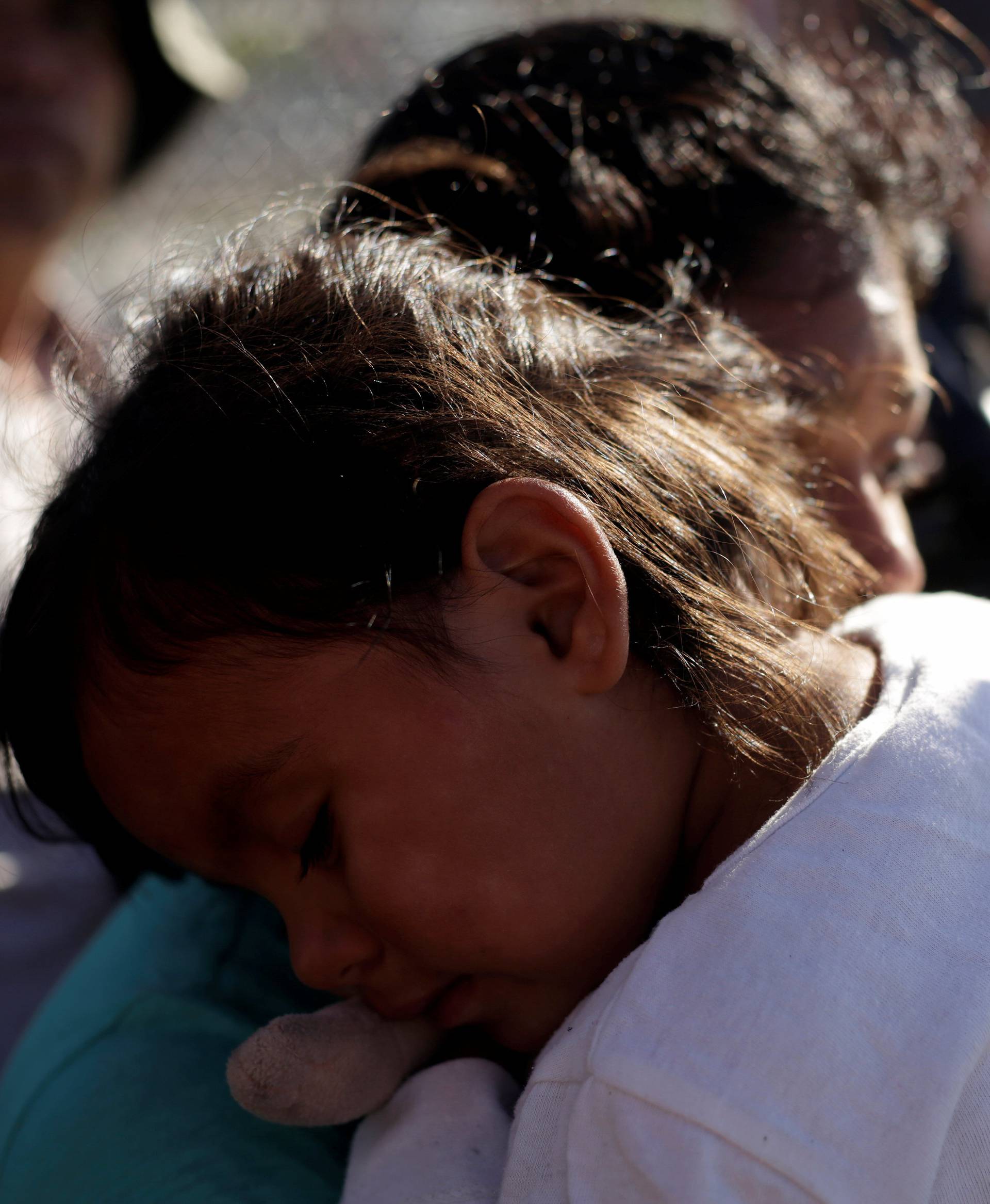 A migrant family from Mexico, fleeing from violence, wait to enter the United States to apply for asylum at Paso del Norte international border crossing bridge in Ciudad Juarez