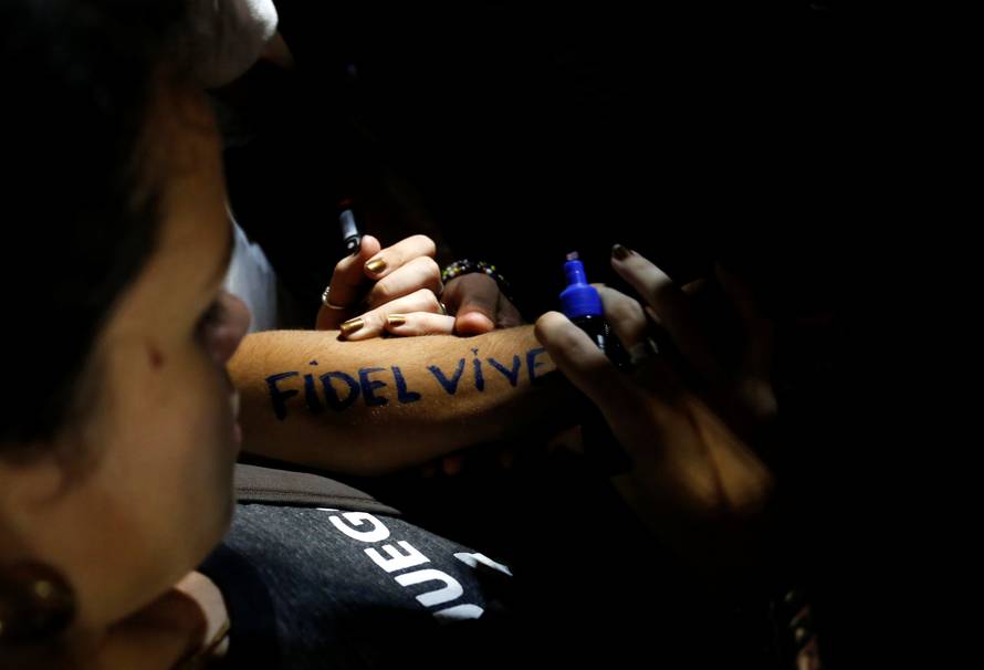 A woman writes "Fidel lives" on her forearm during a massive tribute to Cuba's late President Fidel Castro on Revolution Square in Havana