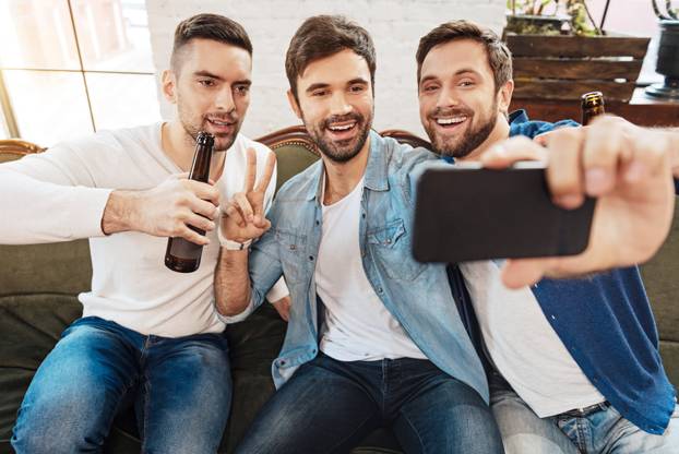 Cheerful bearded man taking a photo