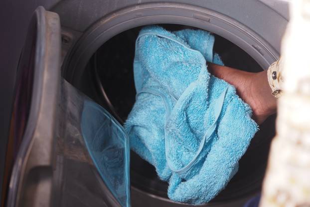 Washing,Towels,Efficiently,Hand,Placing,A,Soft,Blue,Towel,Into