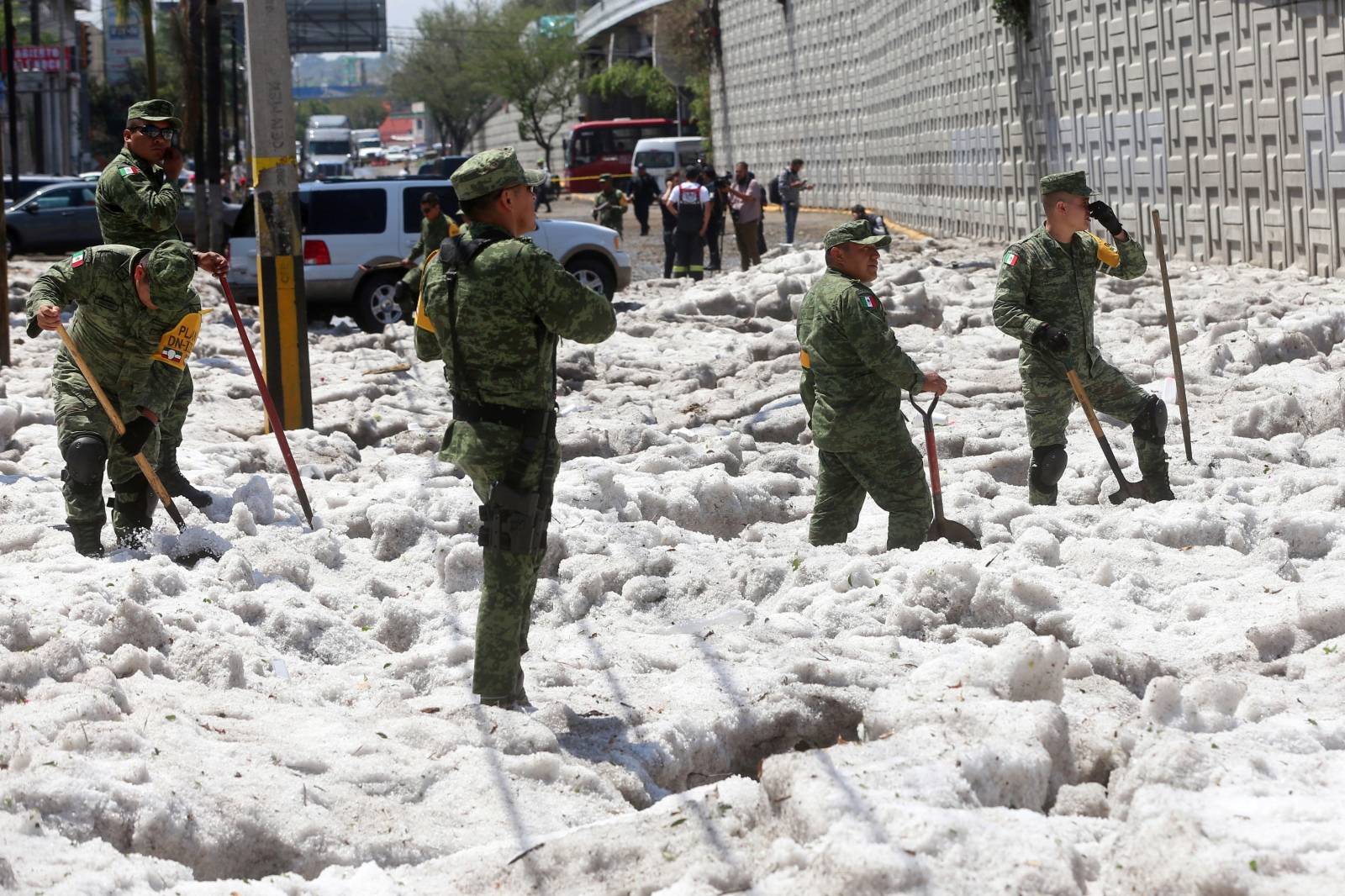 Soldiers try to clear away ice after a heavy storm of rain and hail which affected some areas of the city in ââGuadalajara