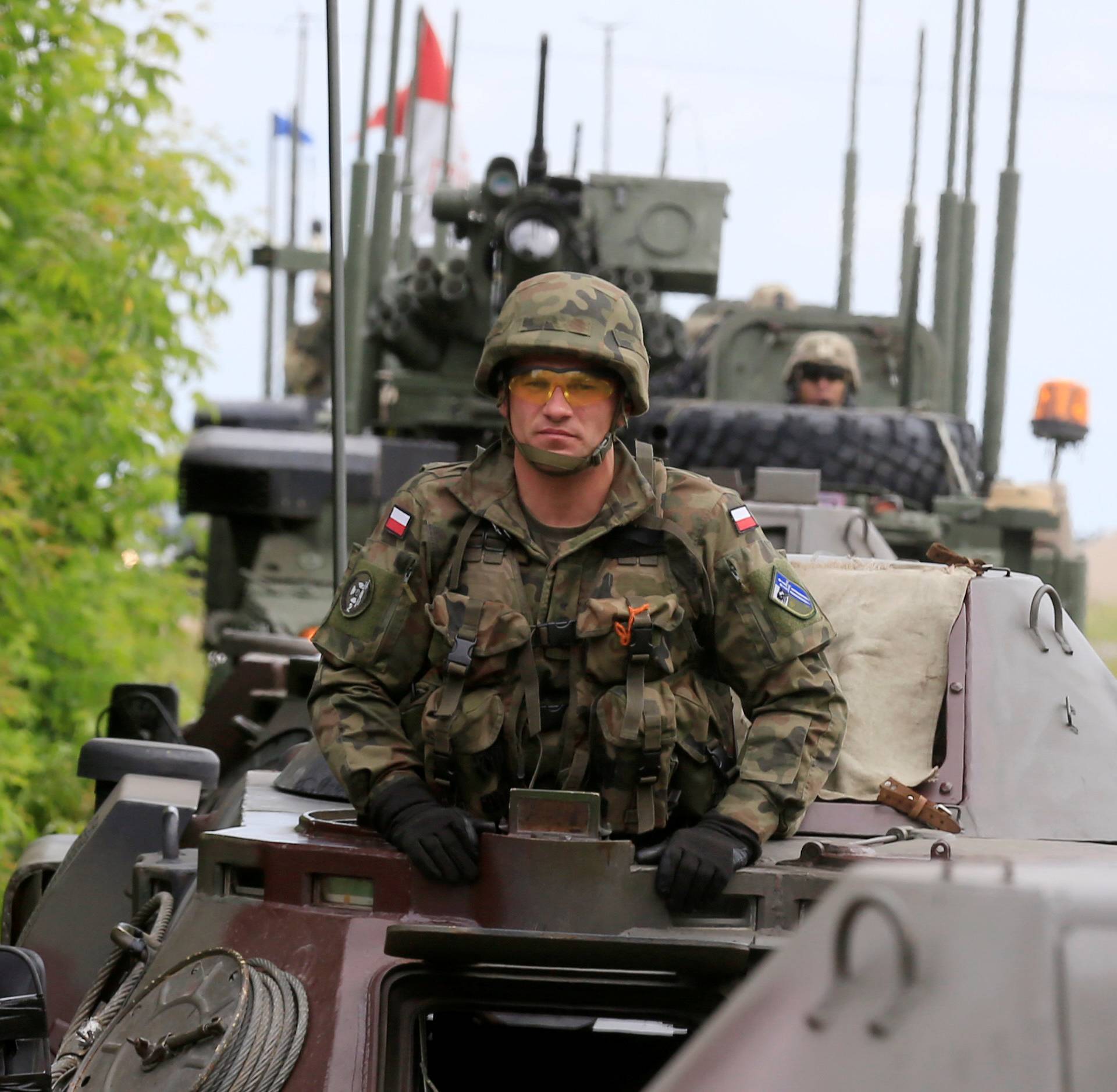 Polish army soldier sits in his armoured fighting vehicle convoy during their ride in Suwalki