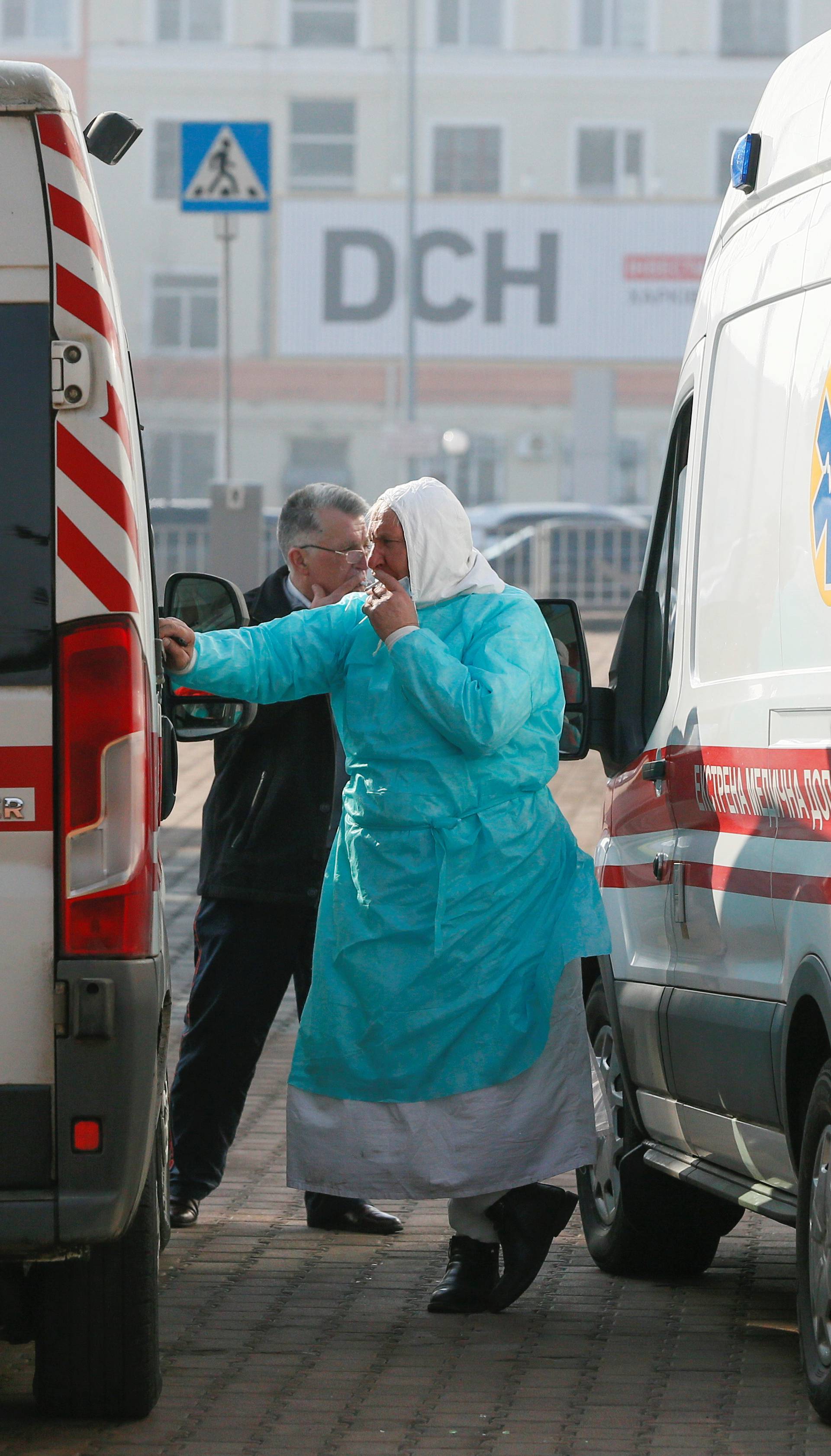 A medic smokes near ambulances in Kharkiv