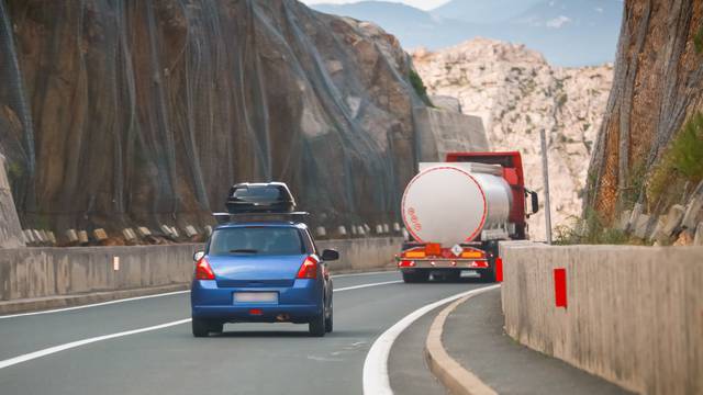 Rear,View,Of,Car,And,Tank,Truck,Driving,Over,Krk