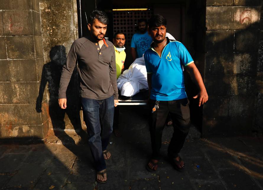 Family members and friends carry the body of a victim killed in a fire at a restaurant from a hospital in Mumbai