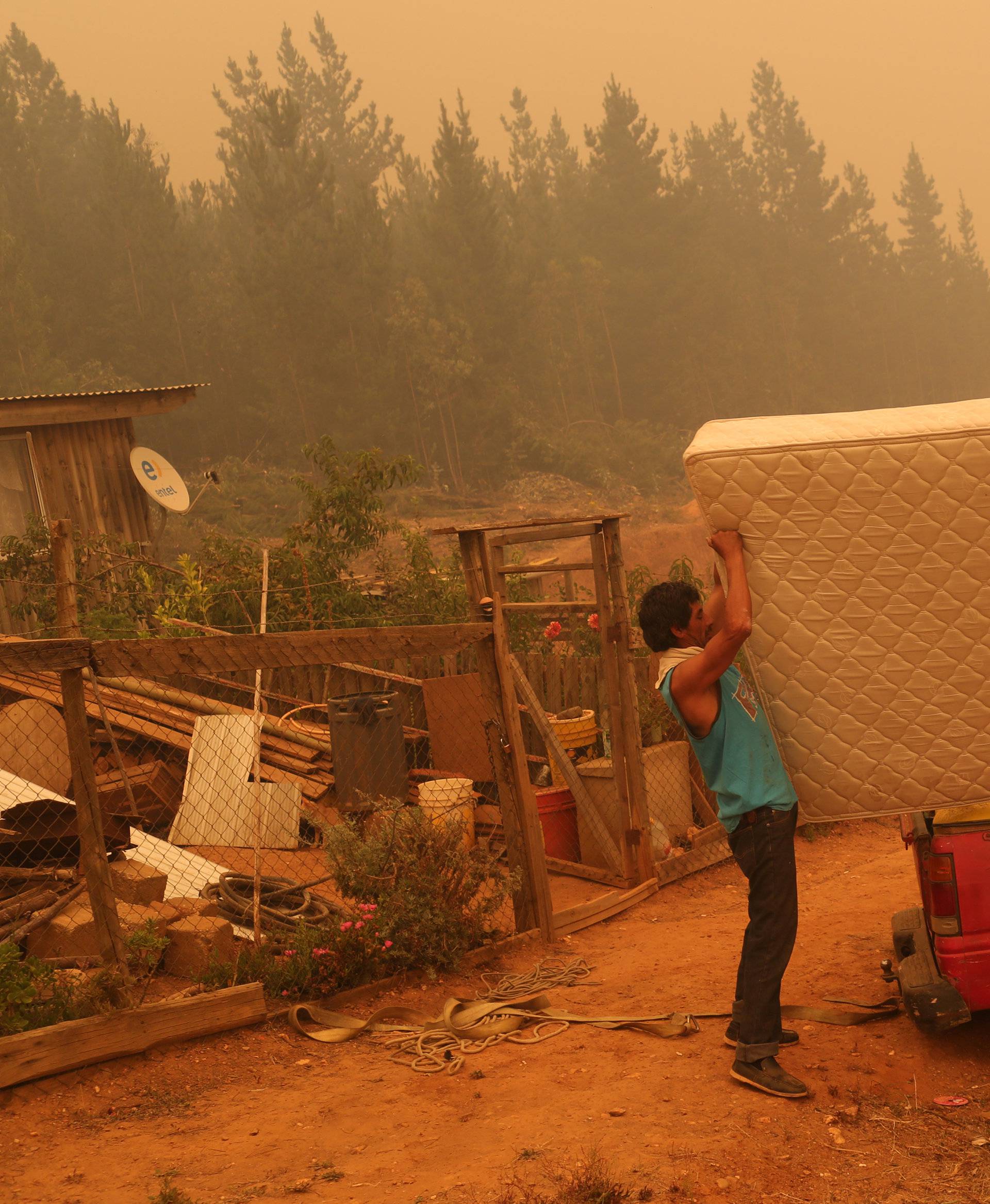 People load household goods into their vehicle while they prepare to evacuate the area in Santa Olga