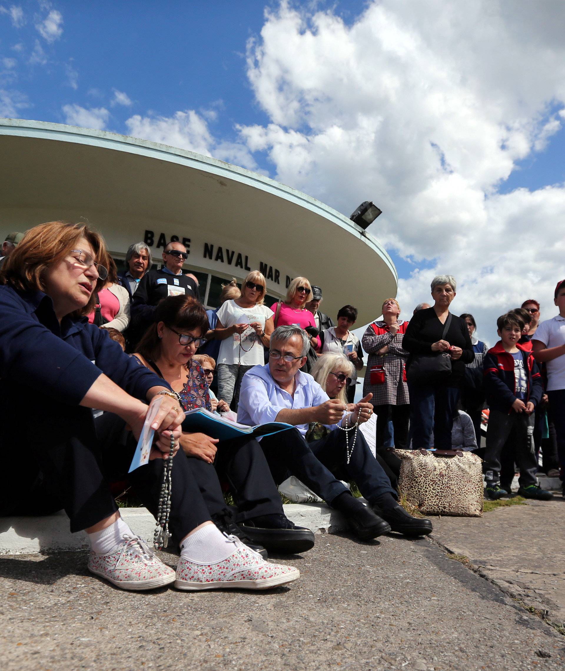 People gather to pray for the 44 crew members of the missing at sea ARA San Juan submarine, at the entrance of an Argentine Naval Base in Mar del Plata