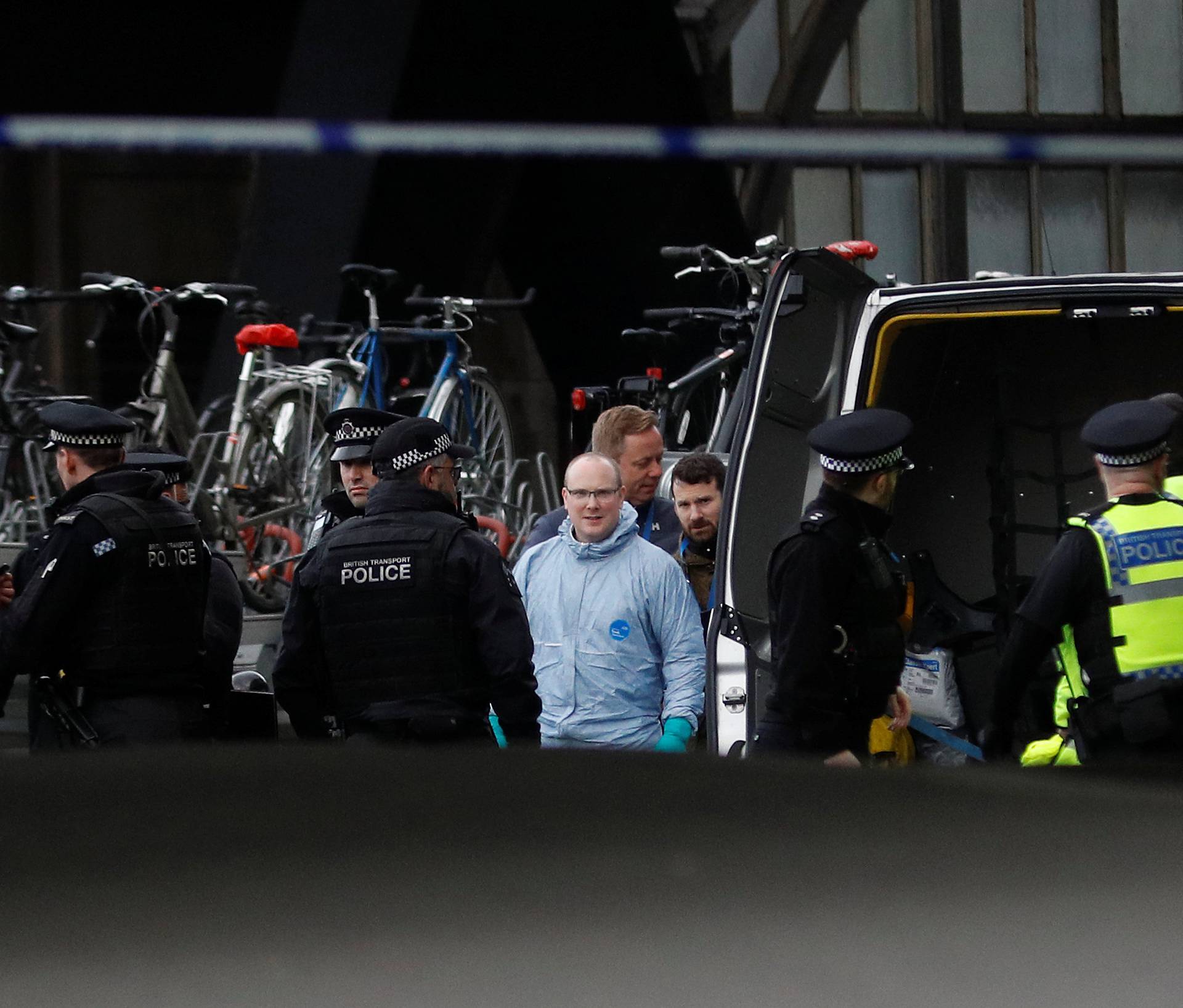 Police officers including one wearing a forensic suit, are seen in a cordoned off area at Waterloo station near to where a suspicious package was found, in London