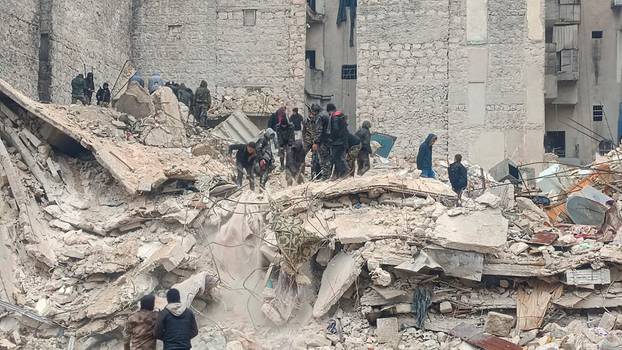 Rescuers search for survivors at the site of a collapsed building, following an earthquake in Aleppo