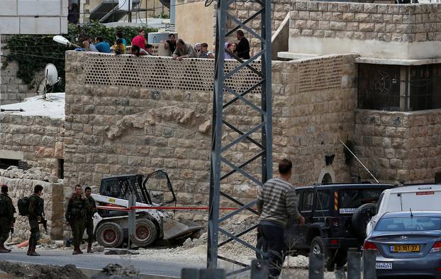 Israeli soldiers stand at the scene of attempted car ramming attack, in Hebron in the occupied West Bank city of Hebron
