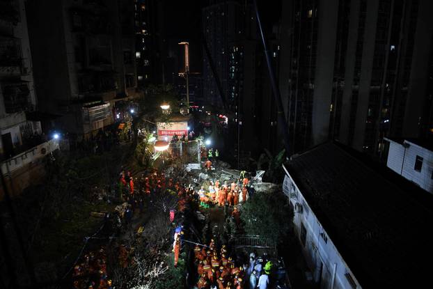 Firefighters at the site where a building housing a canteen collapsed following an explosion, in Chongqing