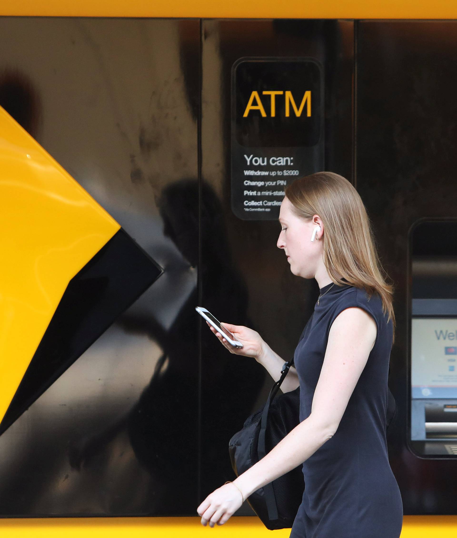 A woman walks past a Commonwealth Bank of Australia logo in Sydney