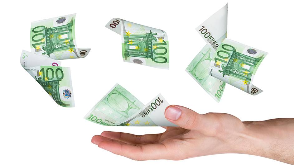 One hundred euro money banknotes flying and falling on young male hand, side view, dark background.