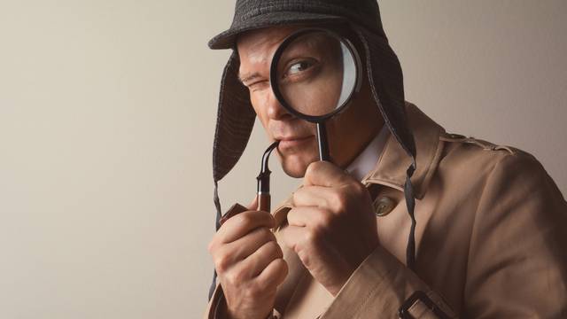 Male,Detective,With,Smoking,Pipe,Looking,Through,Magnifying,Glass,On