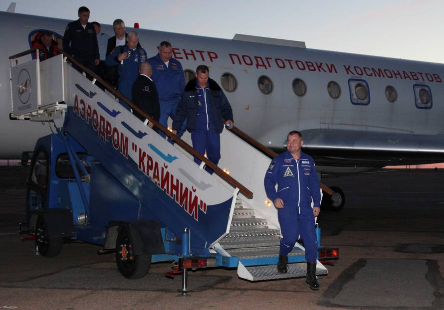 Russian cosmonaut Ovchinin and U.S. astronaut Hague arrive at Baikonur airport