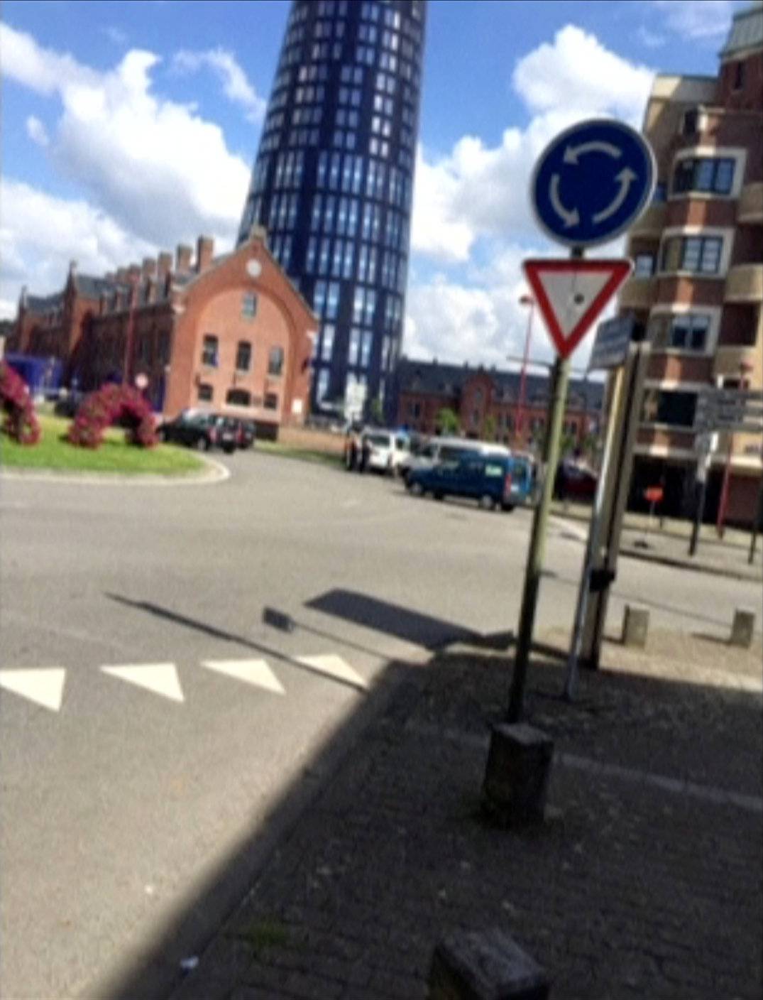 A still image shows the exterior of the police station in Charleroi