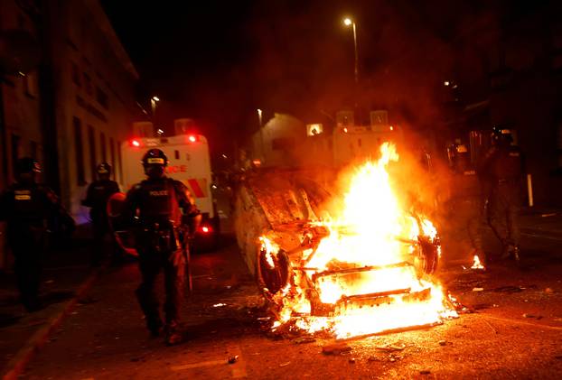 Armed police in riot gear stand guard during a second night of riots, in Ballymena
