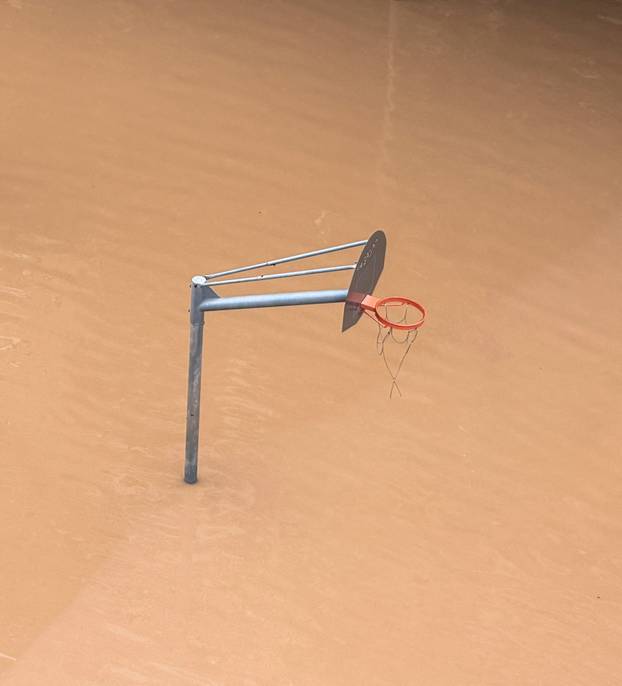 A basketball post stands in a flooded area following heavy rain in Sant Adria de Besos on the outskirts of Barcelona