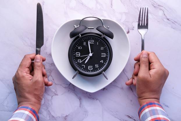 high angle view of clock on plate on wooden table.