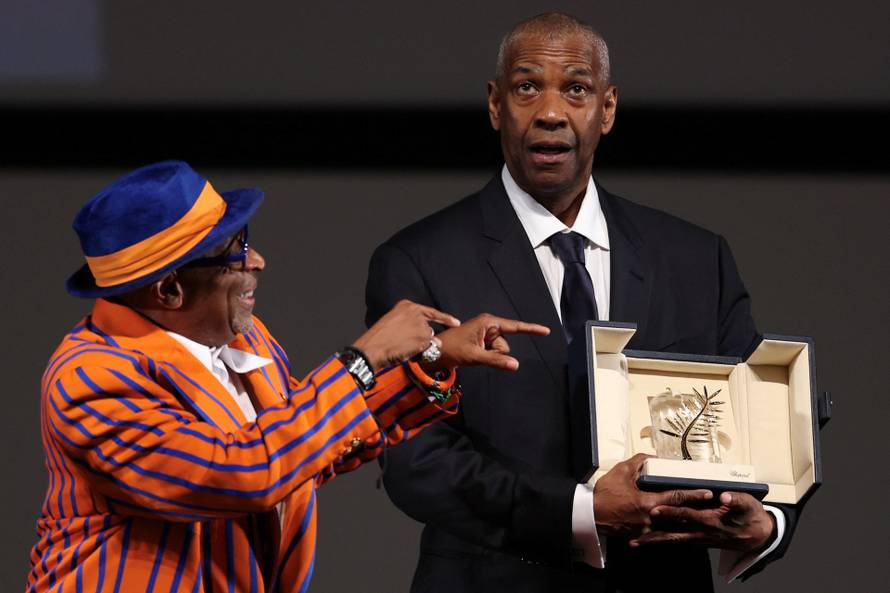 Denzel Washington receives the Honorary Palme d'Or from director Spike Lee, ahead of the screening of the film "Highest 2 Lowest", at the 78th edition of the Cannes Film Festival in Cannes