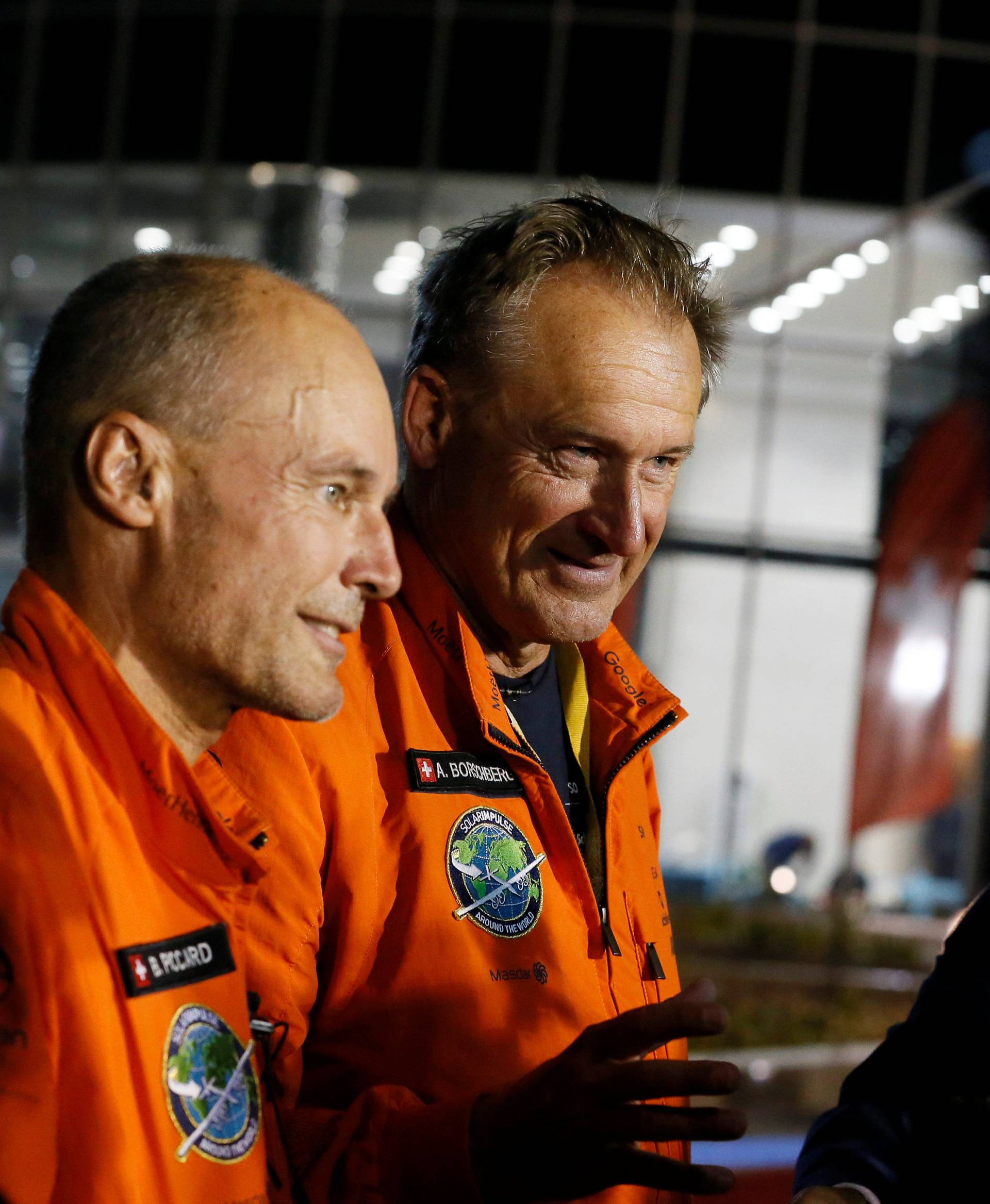 Pilot Andre Borschberg and Bertrand Piccard gesture after their arrival on Solar Impulse 2, a solar powered plane, at an airport in Abu Dhabi, UAE