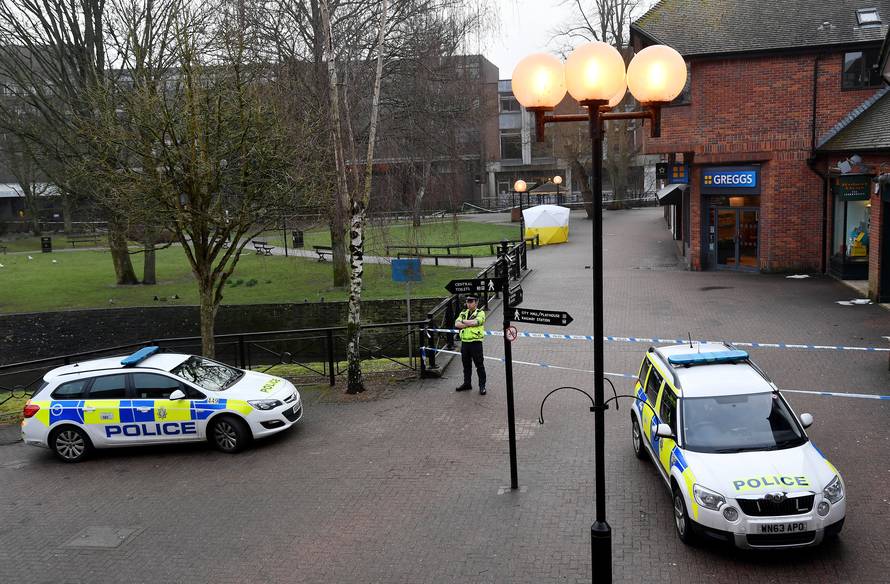 Police officers stand at crime scene tape, as a tent covers a park bench on which former Russian inteligence officer Sergei Skripal, and a woman were found unconscious after they had been exposed to an unknown substance, in Salisbury