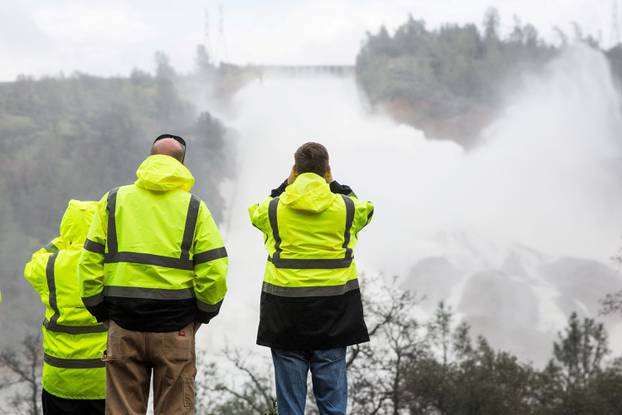 FILE PHOTO:  California Department of Water Resources personnel monitor water flowing through a damaged spillway on the Oroville Dam in Oroville, California