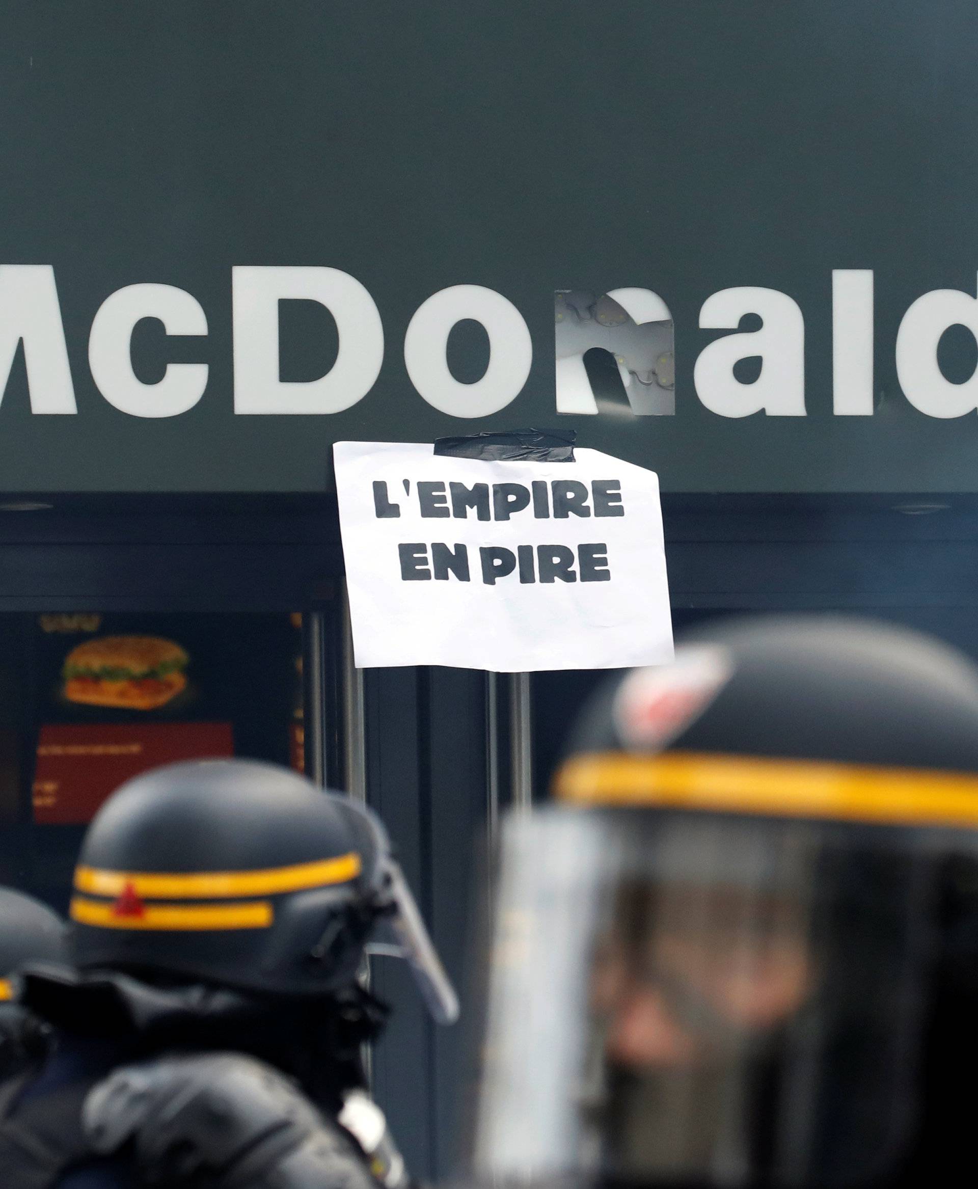 French CRS riot police take position outside a McDonald's during clashes at the May Day labour union march in Paris