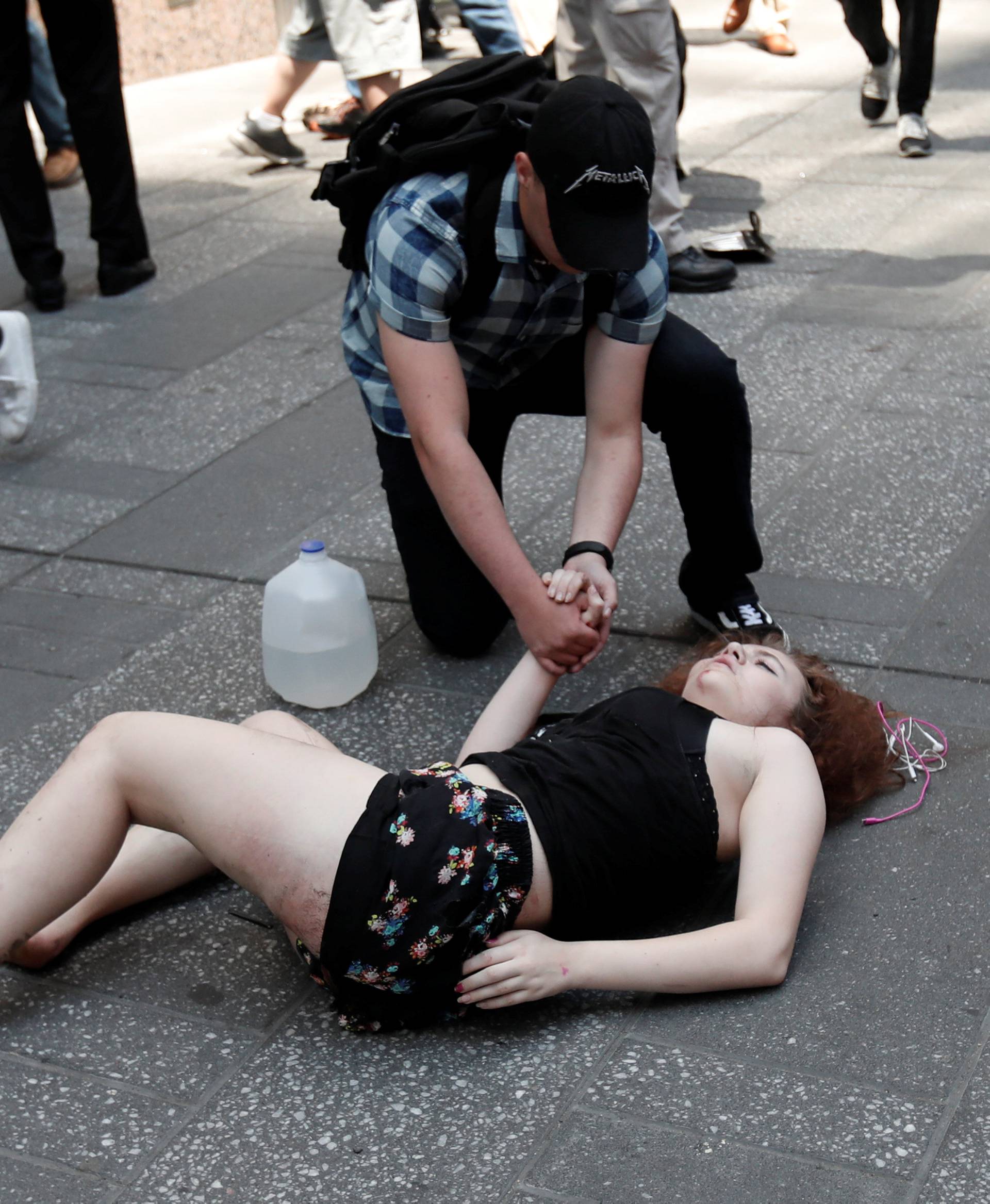 An injured woman lays on the sidewalk in Times Square after a speeding vehicle struck pedestirans on the sidewalk inn New York City,