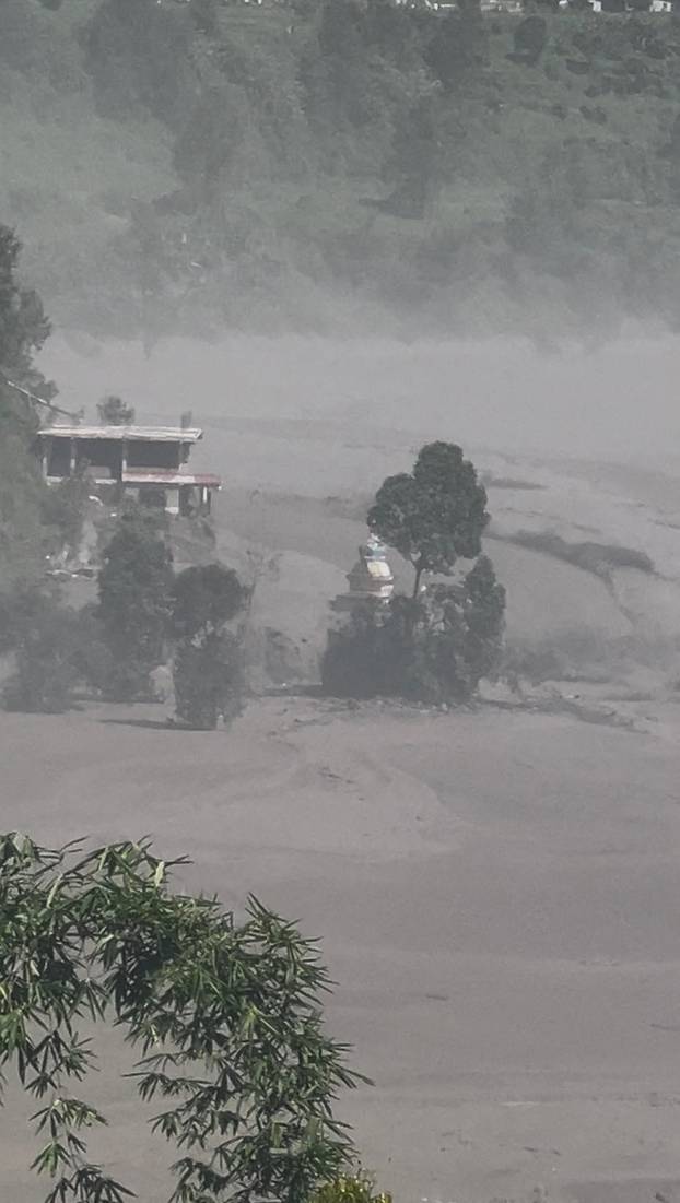 Partially submerged buildings along the riverbank due to a flash flood in Nuwakot district