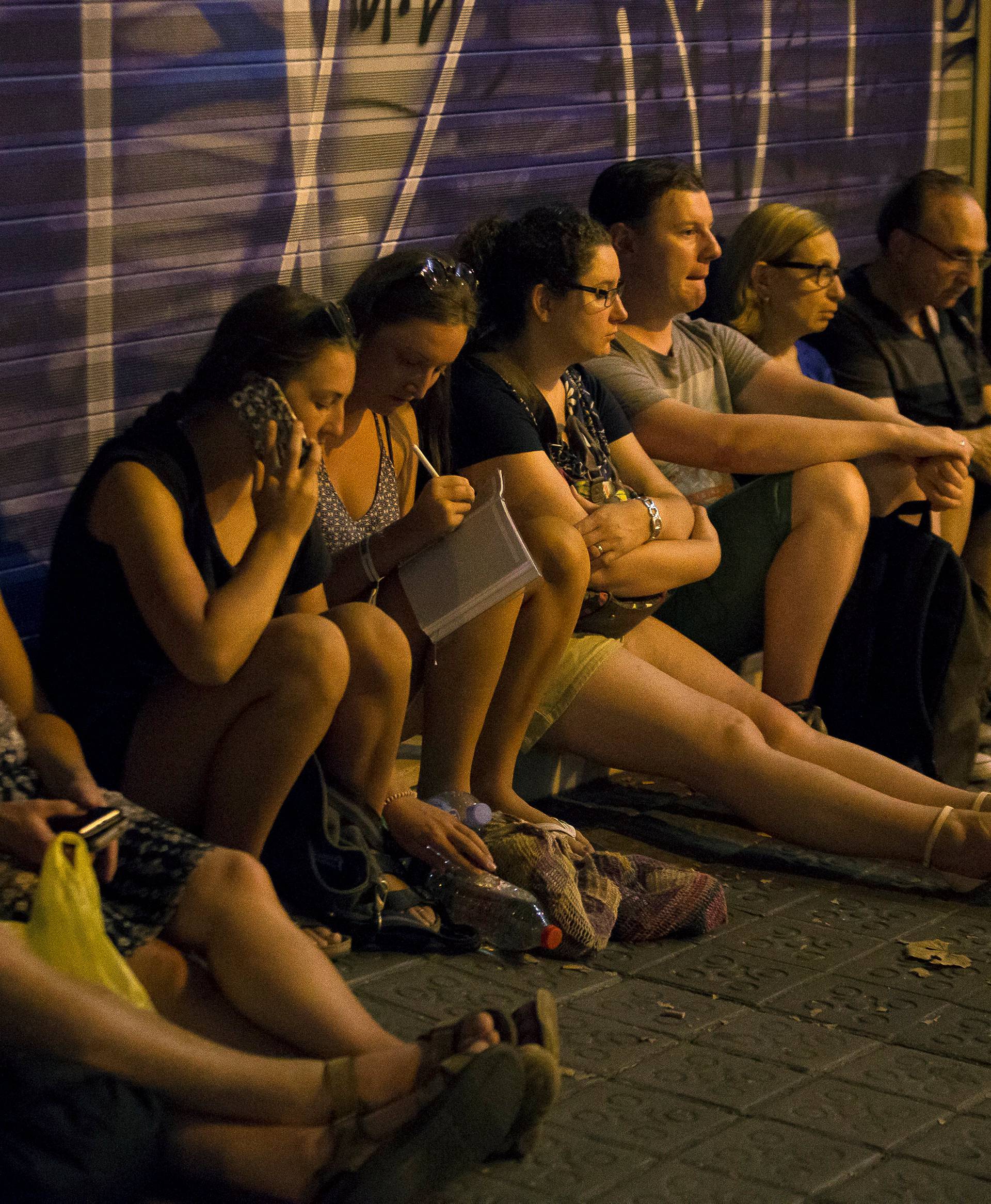 People wait to enter the area after a van crashed into pedestrians near the Las Ramblas avenue in central Barcelona