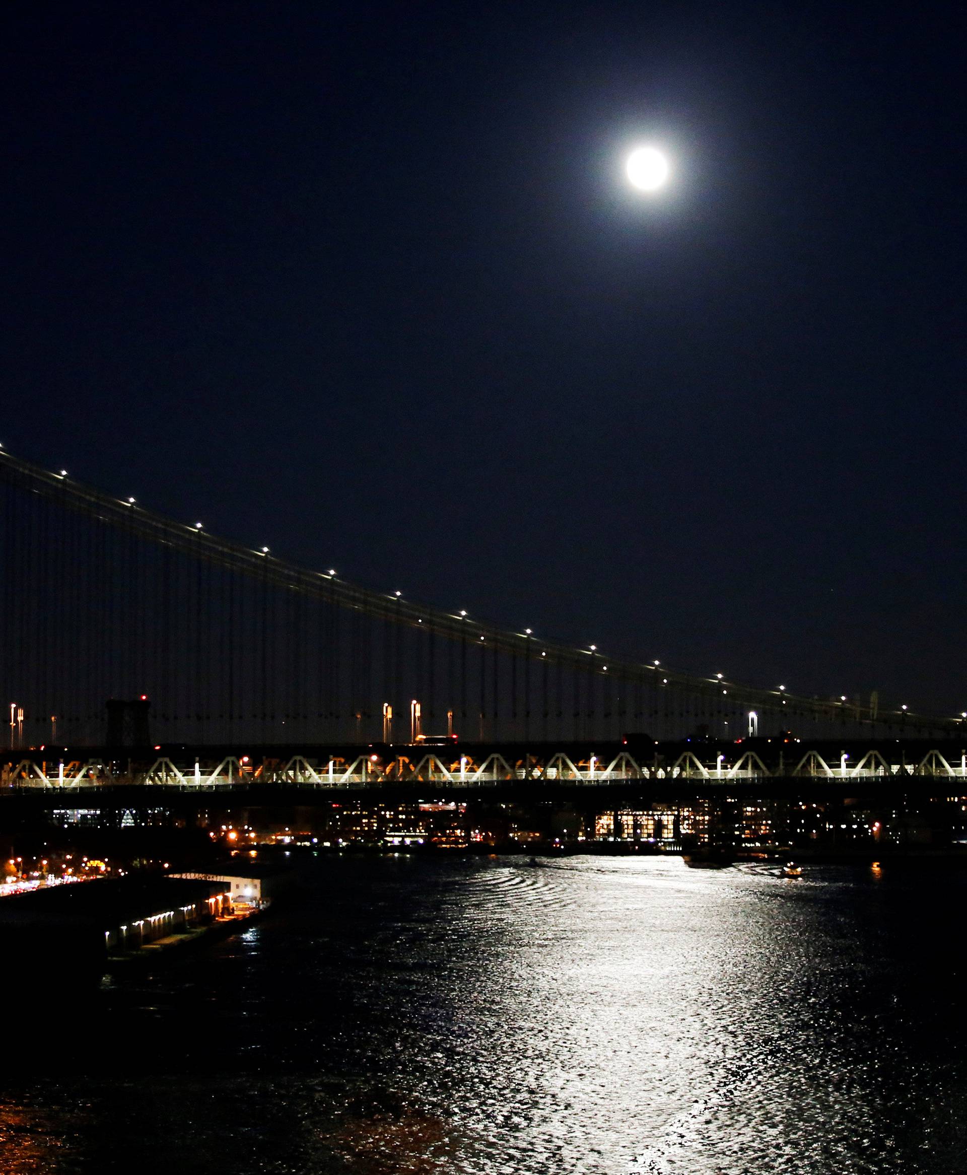 A full moon is seen over the Manhattan Bridge during the eve of the "supermoon" in New York