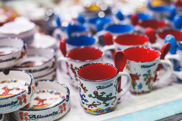 View of traditional tourist souvenirs and gifts from Spain, Alicante, Valencia with toys, bull figures, flamenco dancer dolls, fridge magnets with and key ring keychain, in local vendor souvenir shop