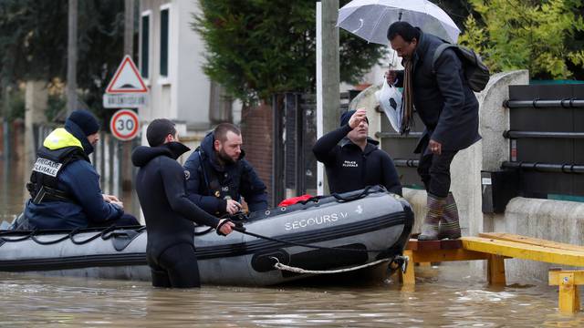 Paris police divers using a small boat patrol a flooded street of a residential area in Villeneuve-Saint-Georges