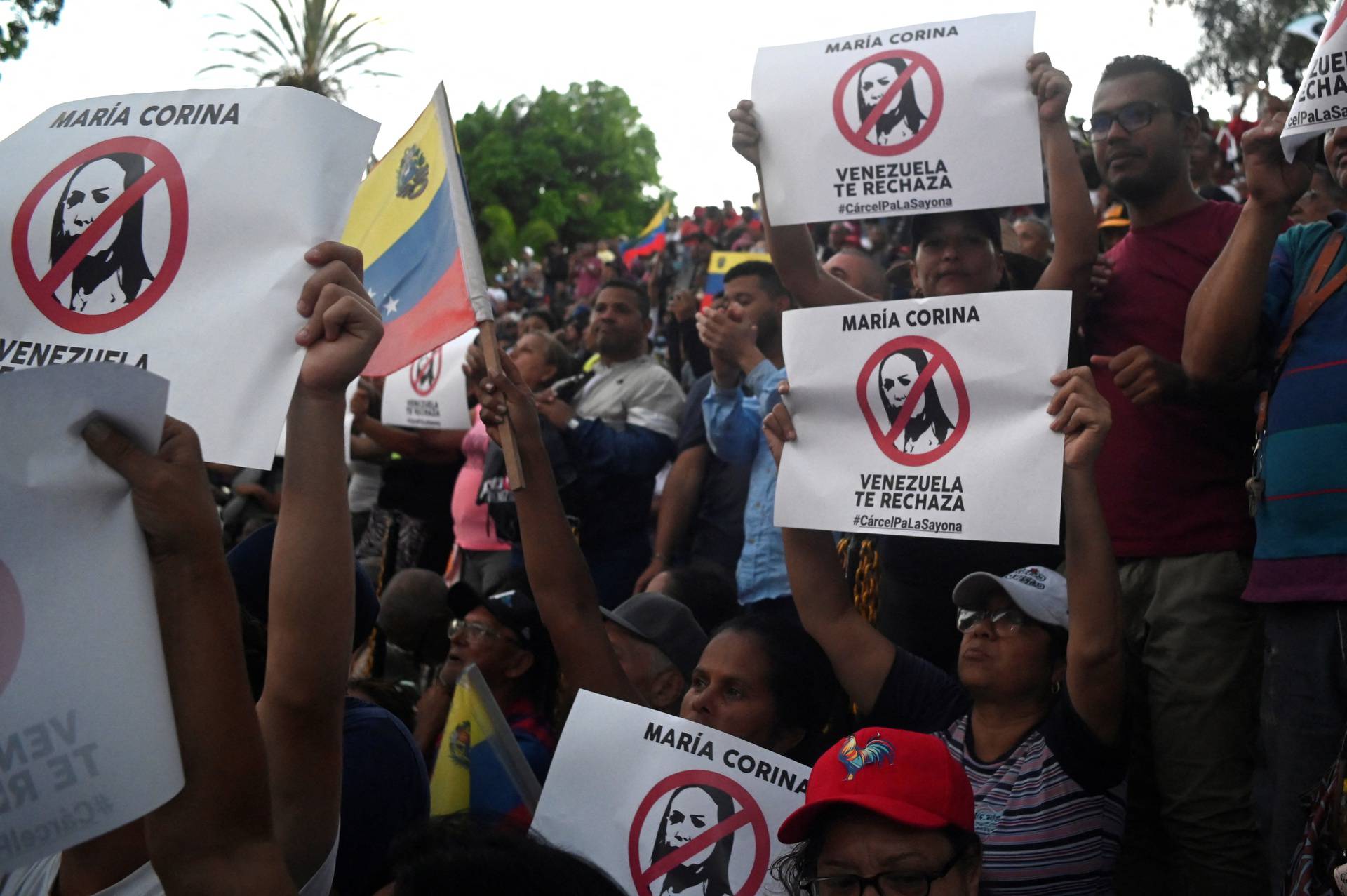 Supporters of Venezuelan President Nicolas Maduro hold posters depicting opposition leader Maria Corina Machado during a rally at Miraflores Palace